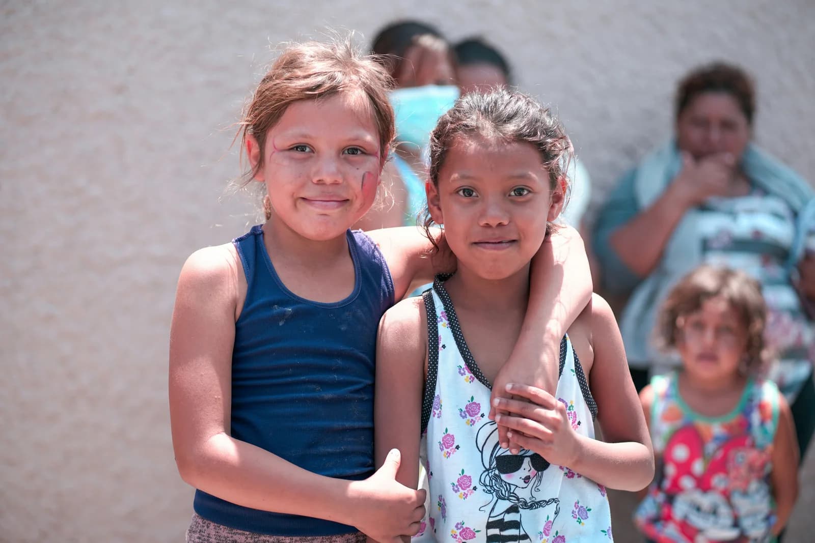 Dos niñas abrazadas en una comunidad